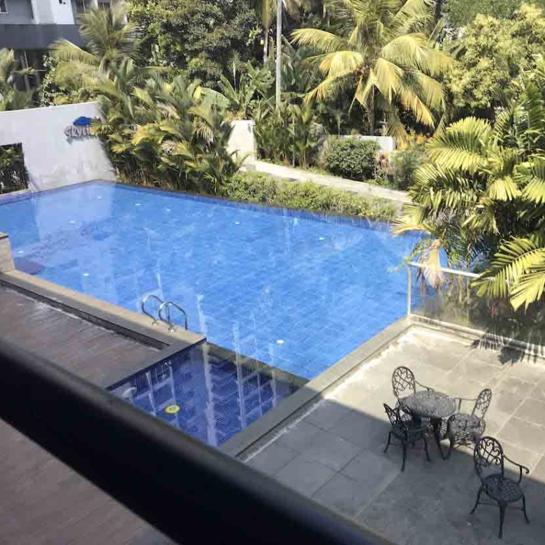 Luxury swimming pool and outdoor lounge area at Skyline The Edge, a premium 3-bedroom flat for sale in Thiruvalla.