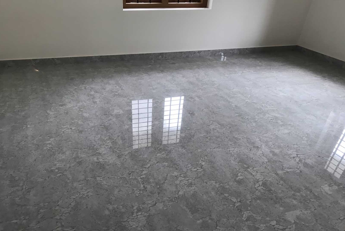 Spacious bedroom interior with premium grey marble-finish floor tiles in a new 2-storey house for sale in Pullad, Thiruvalla.