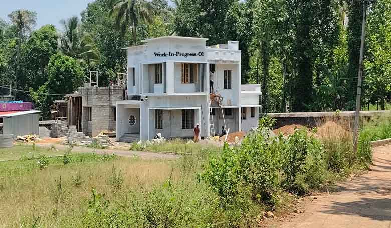 Wide view of a new 4 BHK house under construction in Thiruvalla, Kerala, showing the road access and 8-cent plot near IPC Hebron.