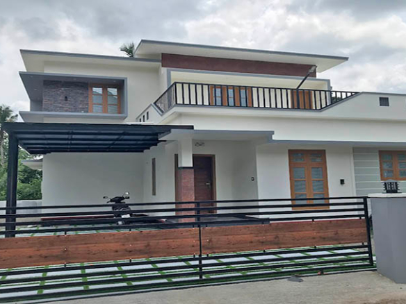 Modern 2-story 3-bedroom house for sale in Eraviperoor, Thiruvalla, Kerala. Features white exterior, gated yard, and upper terrace.