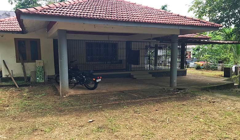 Covered porch and sit-out with traditional tiled roof of a 2 BHK house in Kareelamukk, Thiruvalla