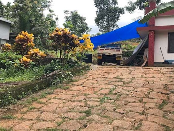 Mini lorry parked on a stone-paved driveway leading to the land plot for sale in Chengannur Kerala.