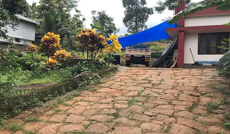 Mini lorry parked on a stone-paved driveway leading to the land plot for sale in Chengannur Kerala.