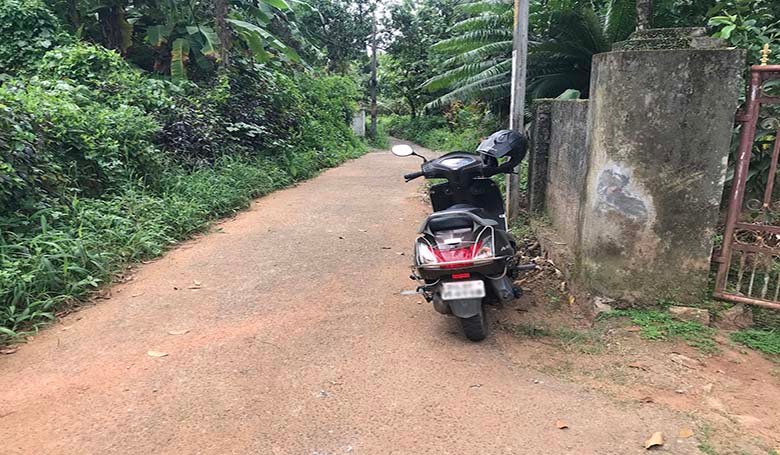 Motor scooter parked along the tarred sub-road in front of the land and to the Vittil Junction Road Chengannur.