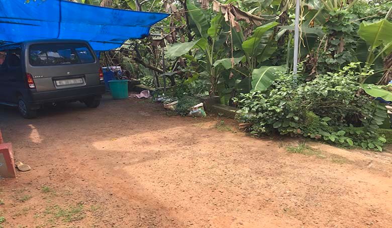 Four-wheeler vehicle parked on the access road leading to the 70 cents land plot for sale in Chengannur Kerala.