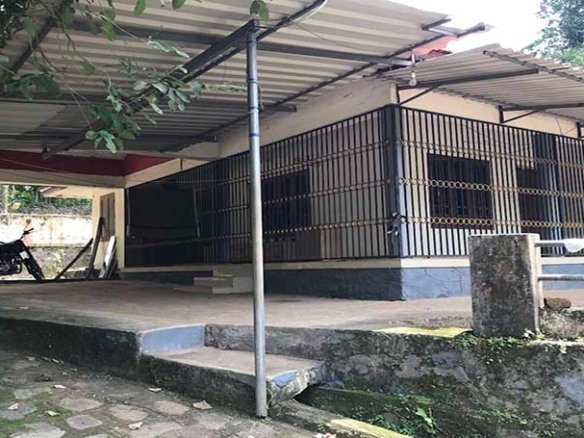 Exterior view of a 2 BHK house with metal roofing sheet extended porch and grill structure in Thiruvalla